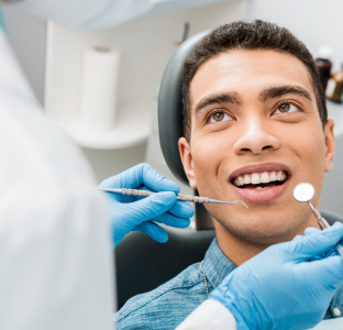 Male dentist sitting talking to a patient sitting in his dentist chair