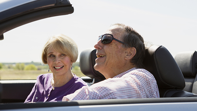 old couple traveling in a convertible